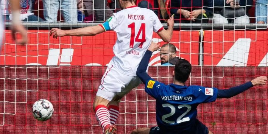 Kölns Jonas Hector (l) erzielt gegen Kiels Atakan Karazor das Tor zum 2:0. Foto: Guido Kirchner