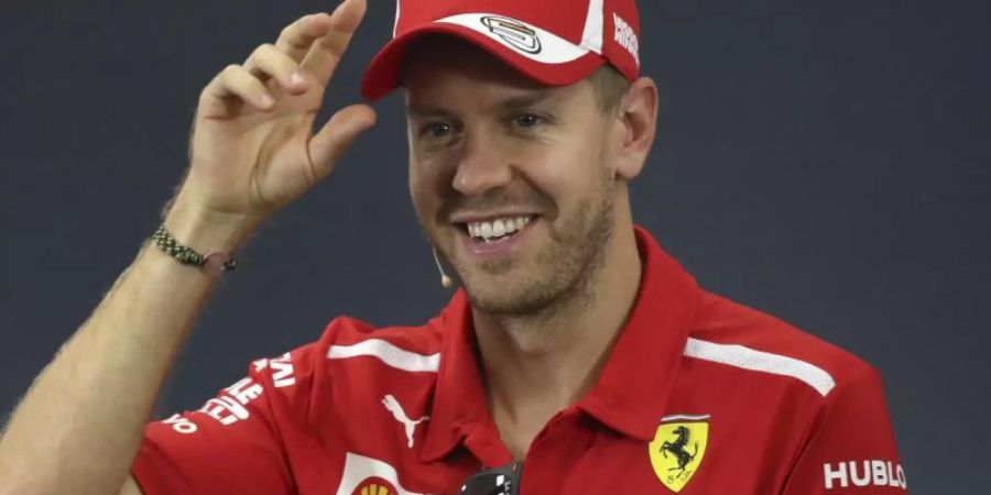 Sebastian Vettel freut sich über den neuen Dienstwagen. Foto (Archiv): Ng Han Guan/AP Foto: Ng Han Guan