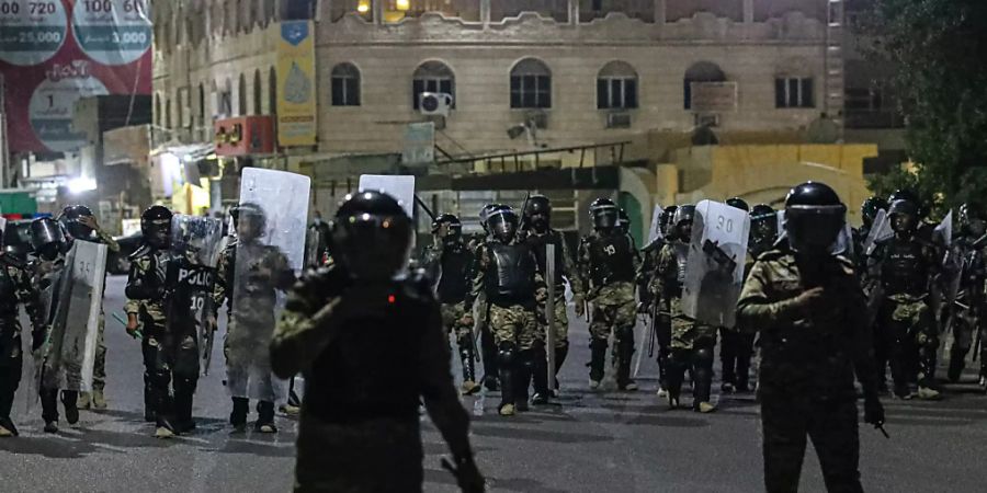 Polizisten versuchen während eines Protests in Basra Demonstranten daran zu verhindern, ein Regionalbüro des Parlaments zu stürmen. Foto: Nabil Al-Jurani/AP/dpa