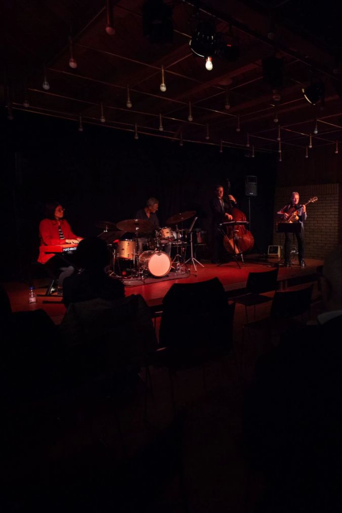 Das Publikum hört den Musikern mit Freude beim spielen zu.