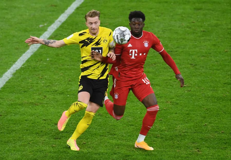 Marco Reus (l.) im Zweikampf mit Alphonso Davies (r.).