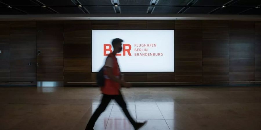 Passant vor dem Logo des BER