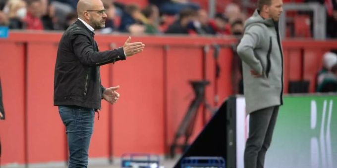 Leverkusens Trainer Peter Bosz (l) und sein Leipziger Kollege Trainer Julian Nagelsmann beobachten das Spiel. Foto: Federico Gambarini/dpa