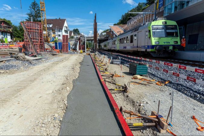 Das Fundament für den neuen Perron steht ... und schon wieder fährt ein Zug vorbei