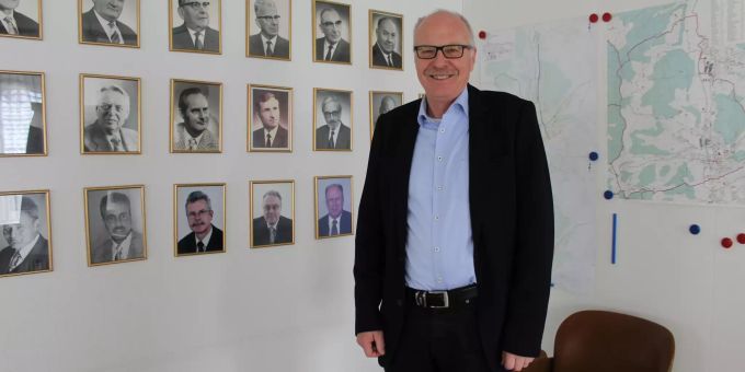 Gemeindeammann Emil Huber vor der Fotowand mit Gesichtern früherer Gemeinderatsmitglieder und Gemeindeammänner. Emil Huber