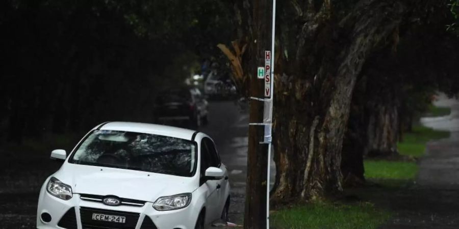 Ein Auto steht in einer überfluteten Strasse in Sydney. Schwere Unwetter haben weite Teile Australiens heimgesucht. Foto: Joel Carrett/AAP/dpa