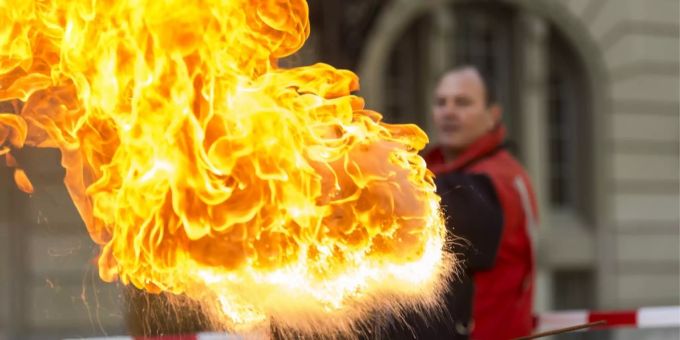 Ein Mitglied der freiwilligen Feuerwehr Bern demonstriert die Wirkung, welche ein Löschversuch einer brennenden Ölpfanne mit Wasser hat. (Archivbild 2012) feuerwehr