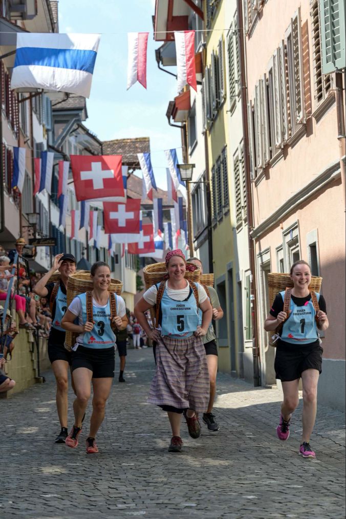Mit handgeflochtenen Hutten laufen die Frauen am Chriesisturm.