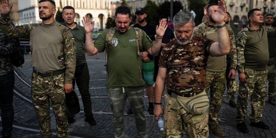 Eine Gruppe ukrainischer Soldaten betet während eines von einer örtlichen christlichen Kirche organisierten Gottesdienstes.