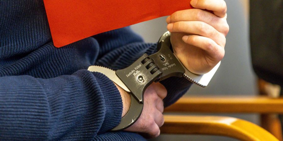 Der Angeklagte sitzt in Handschellen im Gerichtssaal. Nach einem Messerangriff an der Hochschule Hamm-Lippstadt mit einer Toten und drei Verletzten hat das Dortmunder Schwurgericht ein Urteil gesprochen.