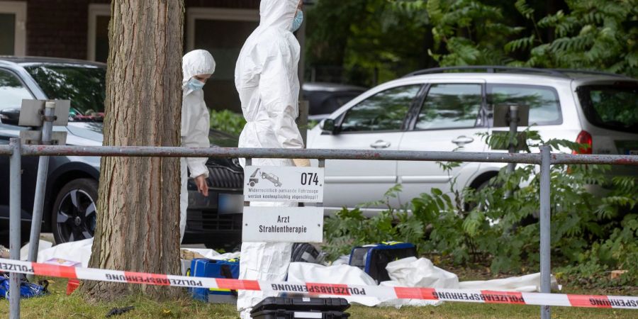 Mitarbeiter der Spurensicherung sind am Tatort von zwei Toten auf dem Gelände eines Krankhauses im Einsatz.
