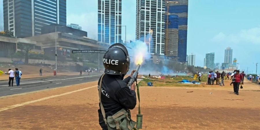 Polizist in Colombo feuert Tränengas auf Demonstranten