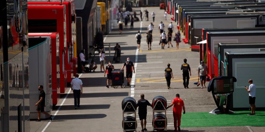 Menschen laufen durch die Paddocks auf der Rennstrecke in Montmelo.