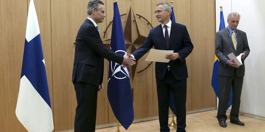 Der finnische Botschafter Klaus Korhonen (l) und der schwedische Botschafter Axel Wernhoff (r) überreichen dem Nato-Generalsekretär Jens Stoltenberg in Brüssel die Anträge ihrer Länder auf die Nato-Mitgliedschaft. Schweden und Finnland haben am Mittwoch die Mitgliedschaft in der Nato beantragt. Foto: Heta Hassinen/Lehtikuva/dpa