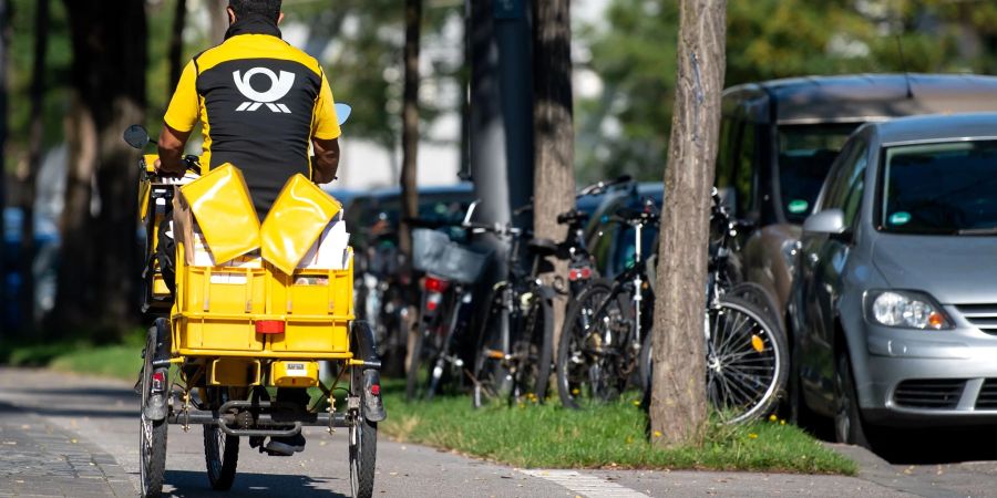 Ein Briefträger mit seinem Fahrrad: Im Jahr 2025 rechnet die Deutsche Post damit, dass fünf Briefe auf ein Paket kommen.