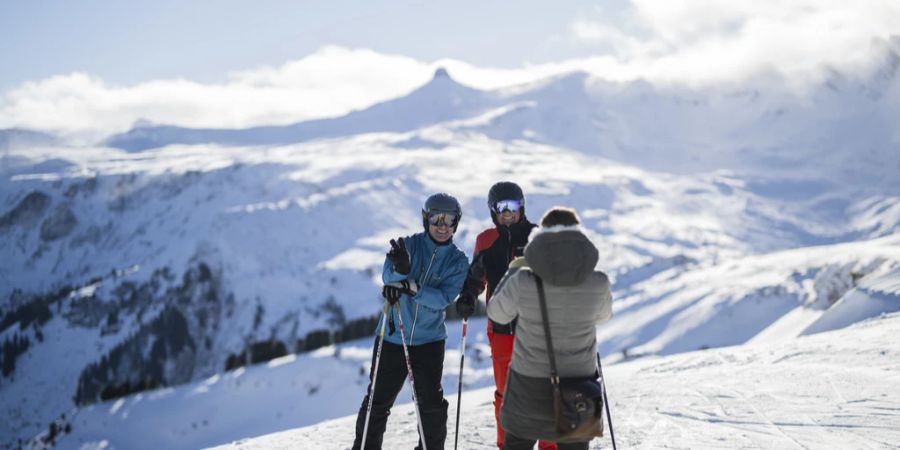 Skifahrer machen ein Foto auf dem Maschgenkamm mit Blick auf den Spitzmeilen im Skigebiet Flumserberg SG.