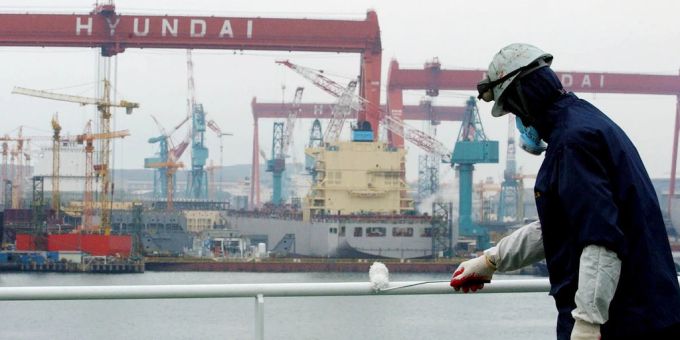 Ein Mann streicht ein Schiff im Hafen von Uslan in Südkorea. südkorea