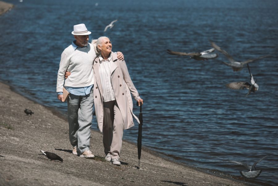 Seniorenpaar spaziert am Wasser