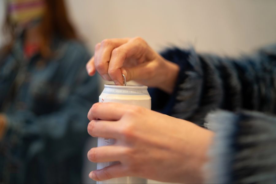 Person öffnet Getränkedose