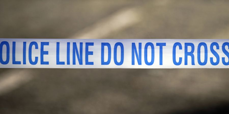 ARCHIV - Ein Absperrband der britischen Polizei, aufgenommen in der Nähe eines mutmaßlichen Tatortes. Foto: Peter Byrne/Press Association/dpa (Archivbild)