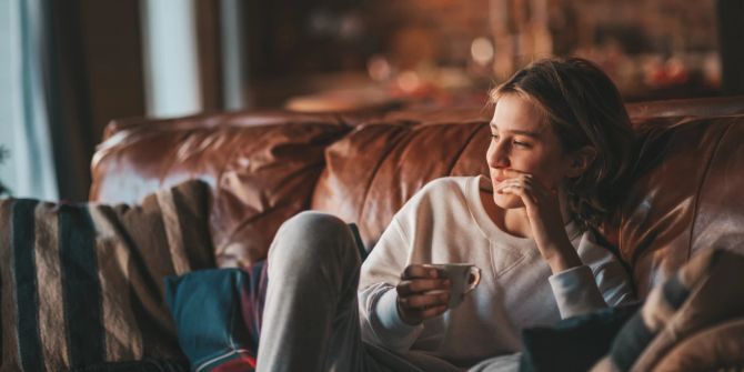 Entspannte Frau mit Teetasse auf einem Sofa