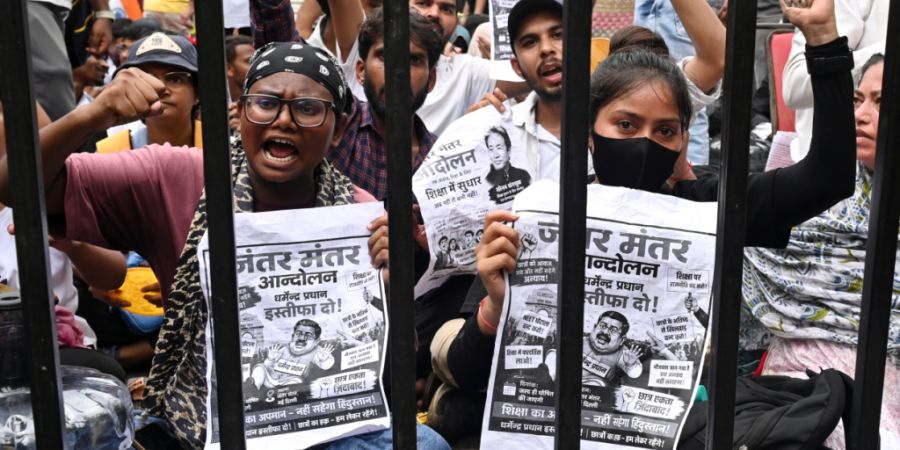Demonstranten in der indischen Hauptstadt skandieren Parolen und tragen Plakate, auf denen sie den Rücktritt des indischen Bildungsministers Pradhan fordern. Foto: Vipin/AP/dpa