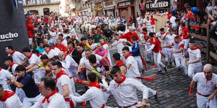 Feiernde laufen beim ersten Stierlauf des San-FermÌn-Festes neben den Kampfstieren von Fuente Ymbro her. Foto: Miguel Oses/AP/dpa