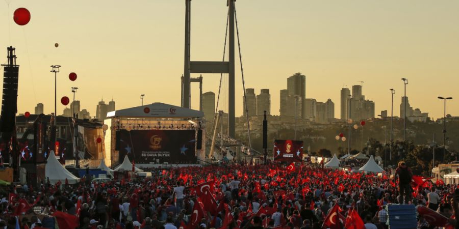 ARCHIV - 15.07.2018, Türkei, Ankara: Menschen schwenken türkische Flaggen bei einer Gedenkveranstaltung zum zweiten Jahrestag des Putschversuchs auf der Brücke der Märtyrer des 15. ...