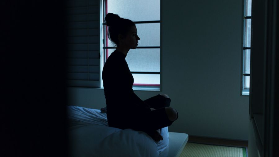 Frau meditiert im Bett
