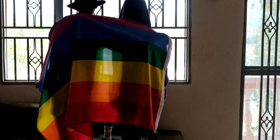 Ein Paar mit einer Pride-Fahne: Die rechtliche Situation offen queerer Menschen ist nicht nur in Uganda schwierig.