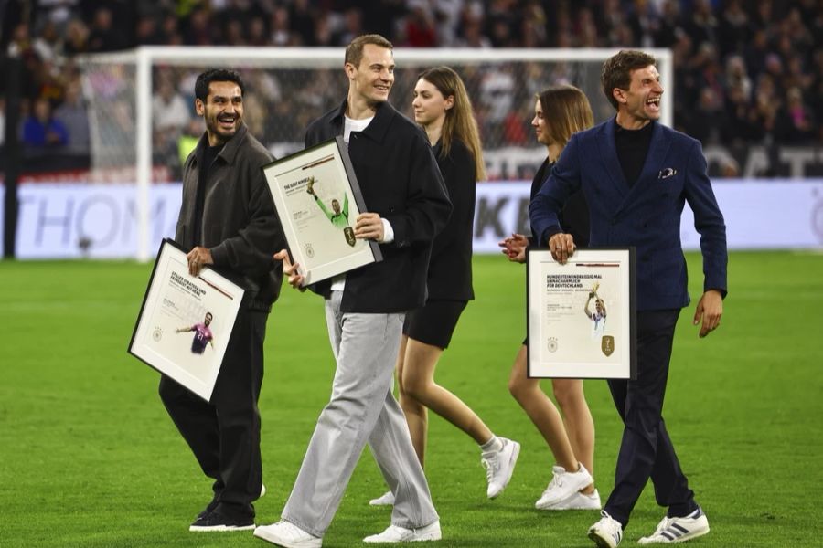 Vor dem Anpfiff in München werden die aus der DFB-Elf zurückgetretenen Spieler Ilkay Gündogan (l), Manuel Neuer (m), Thomas Müller (r) und Toni Kroos (abwesend) verabschiedet.