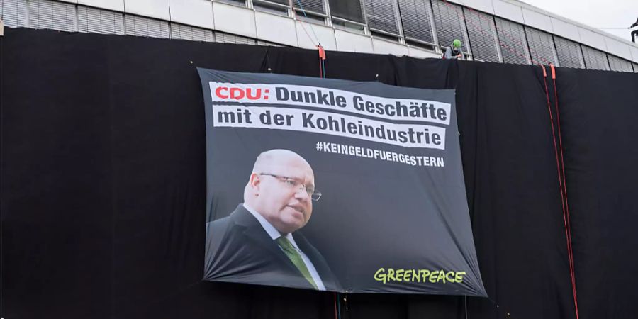 Greenpeace-Aktivisten haben die Parteizentrale der CDU mit schwarzem Stoff verhüllt. Foto: Christophe Gateau/dpa