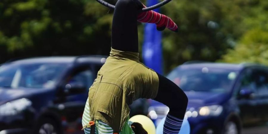 Familien passieren bei der Fahrt durch das «Zirkusland» verschiedene Attraktionen mit Clowns, Jongleuren, Einradfahrern, Seiltänzern und Trapez-Künstlern. Foto: Uwe Anspach/dpa