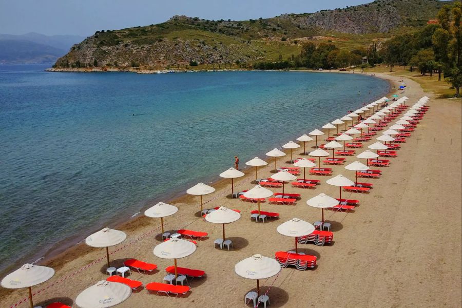 Am Strand von Karathona, in der Nähe von Nafplio, sind die Schirme vor der Öffnung mit jeweils vier Metern Abstand zueinander aufgestellt.