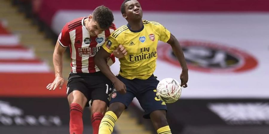 John Egan (l) von Sheffield United und Arsenal-Profi Eddie Nketiah im Kopfballduell. Foto: Oli Scarff/Pool AFP/dpa