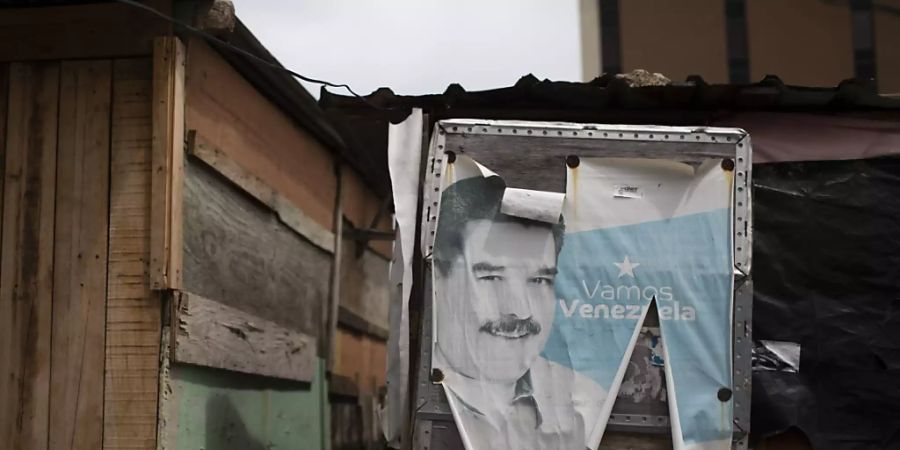 Ein altes Wahlkampfplakat mit dem venezolanischen Präsidenten Maduro bedeckt die Tür einer Baracke in Caracas. Fünf Monate vor den geplanten Parlamentswahlen hat der Oberste Gerichtshof Venezuelas den Vorstand einer der wichtigsten Oppositionsparteien des Landes ausgetauscht. Foto: Ariana Cubillos/AP/dpa