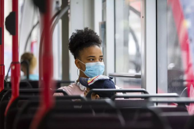 Eine Frau mit Maske fährt Tram in Bern. Maskenpflicht.