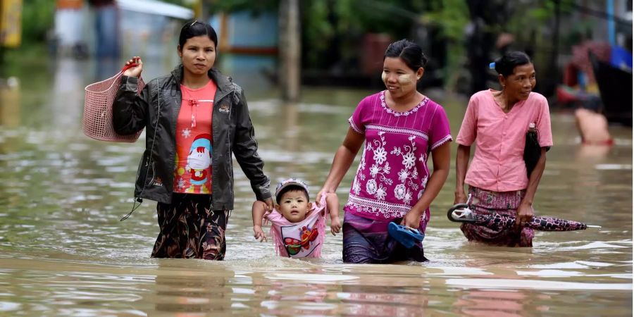 Bewohner waten durch das Hochwasser, zu dem es nach anhaltenden Regenfällen in Myanmar gekommen ist.