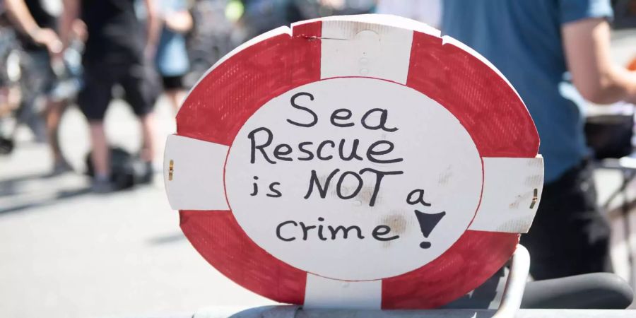 Ein Schild mit der Aufschrift «Sea Rescue is not a crime!» steht in der Nähe einer Kundgebung der Bewegung «Seebrücke». Die internationale Bewegung «Seebrücke» entstand als Reaktion auf die Vorkommnisse um das Rettungsschiff «Lifeline».