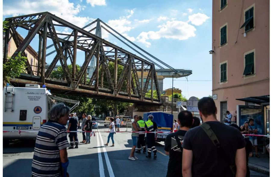 Evakuierte Anwohner stehen auf einer Strasse in der Nähe der teilweise eingestürzten Autobahnbrücke Ponte Morandi.