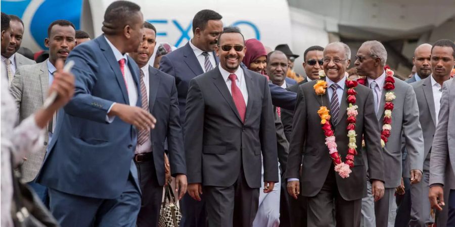 Äthiopiens Premierminister Abiy Ahmed (Mitte) nimmt Eritreas Aussenminister Osman Sale (rechts daneben) am Flughafen in Empfang.