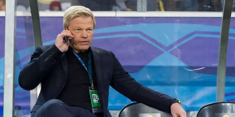 Oliver Kahn sitzt vor dem Spiel auf einer Bank und telefoniert mit seinem Handy.