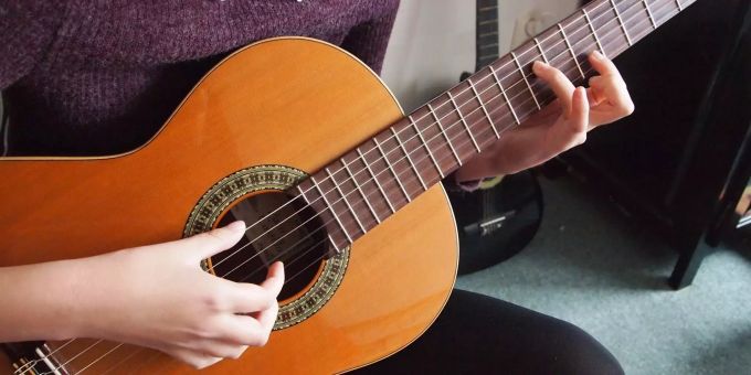 Migros unterstützt junge Musiker. Ein Mädchen spielt an einer Gitarre.