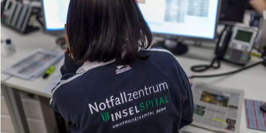 Eine Mitarbeiterin des Notfallzentrums vom Inselspital Bern nimmt am Empfang ein Telefon entgegen.