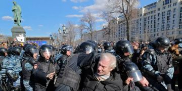 Russische Polizisten nehmen Demonstranten fest.