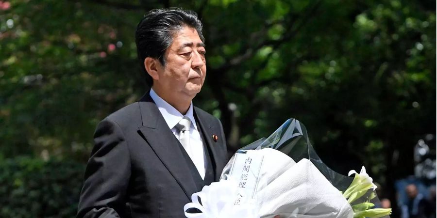 Shinzo Abe, Japans rechtskonservativer Regierungschef, trägt auf dem Chidorigafuchi Nationalfriedhof einen Blumenstrauss.