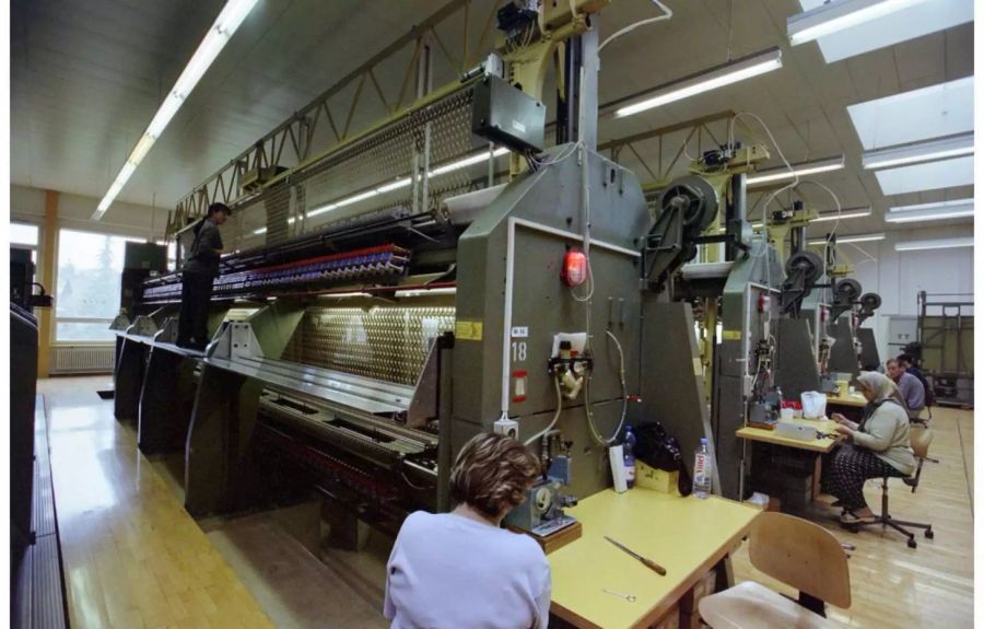 Mitarbeiter in der Bischoff Textil AG an einer Stickereimaschine - Keystone