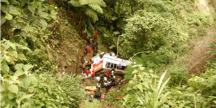 Retter und Sanitäter eilen zu einem verunglückten Passagierbus im Jahr 2010.