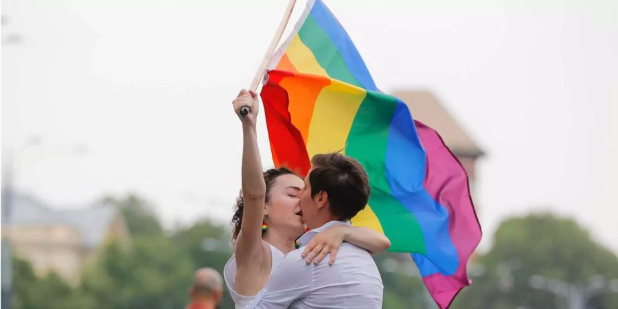 Zwei Frauen küssen sich und halten eine Regenbogen-Fahne während der Gay-Pride-Parade in Bukarest.
