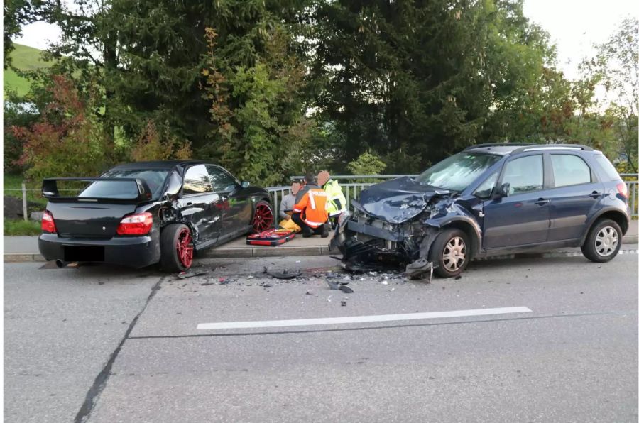 Verunfalltes schwarzes und blaues Auto mit grossem Schaden vorne und Rettungskräfte an der Seite - zvg Kantonspolizei Appenzell Innerrhoden